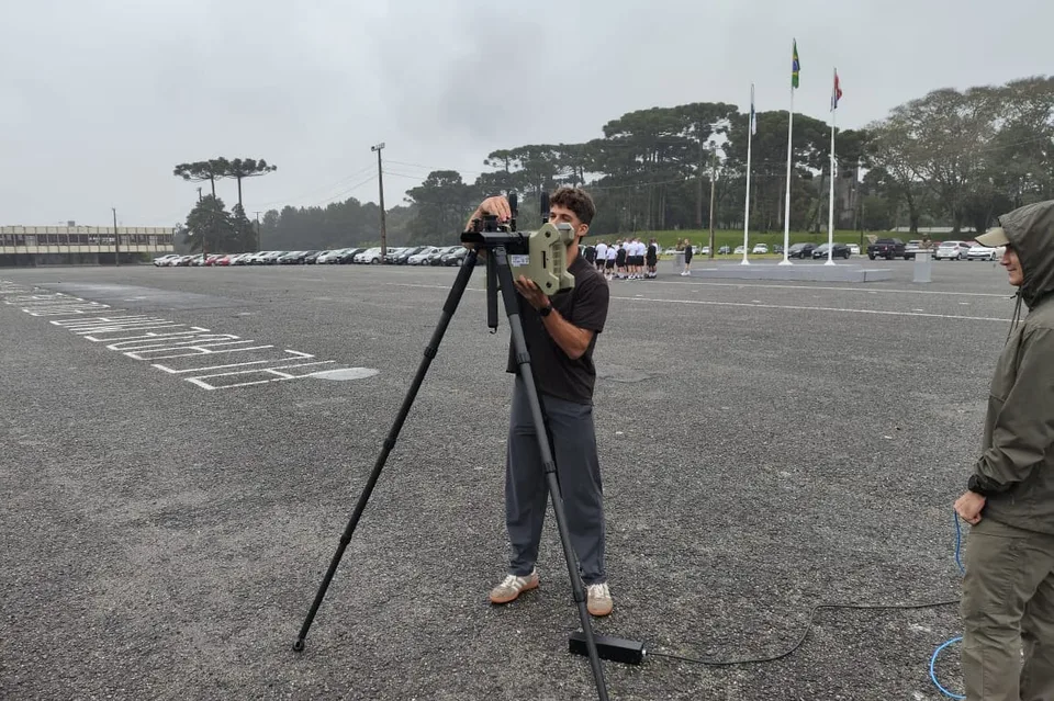 Técnico opera un equipo antidrones de radiofrecuencia instalado sobre trípode en la Academia de Policía Militar de Guatupê, Paraná, el 15 de octubre de 2026.