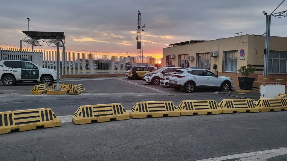 Fotografía real de la zona de control del puerto de Ceuta al amanecer, con vehículo de la Guardia Civil y vallado portuario; archivo publicado en 2025