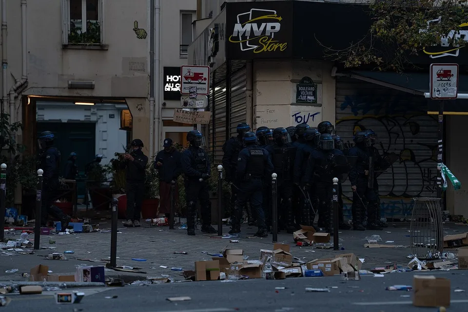 Policías antidisturbios franceses frente a un comercio saqueado entre cajas y escombros en París el 17 de octubre de 2026, fotografía real de Jorge Jaramillo.