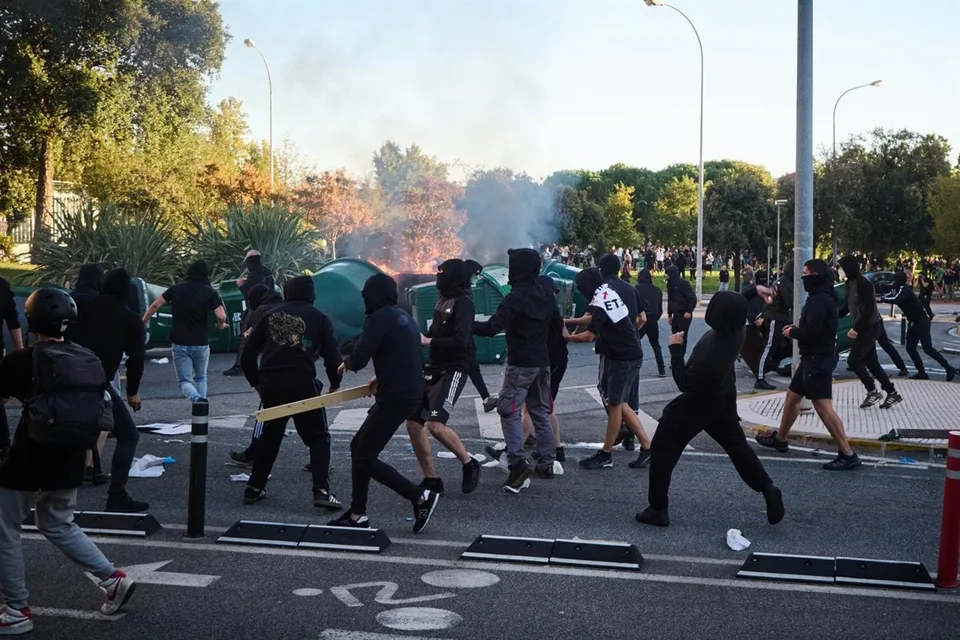 Fotografía real de los disturbios de Pamplona del 15 de octubre de 2026, con presencia de manifestantes y dispositivos de seguridad.