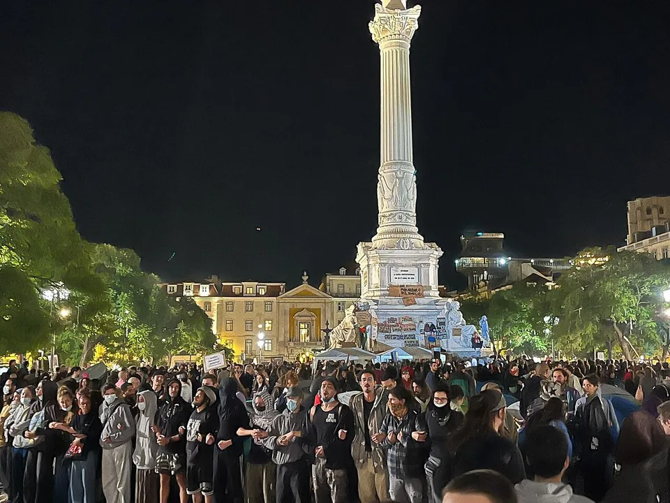 Fotografía real de la protesta y acampada por el derecho a la vivienda en la plaza del Rossio de Lisboa el 18 de octubre de 2026, antes de la intervención policial.