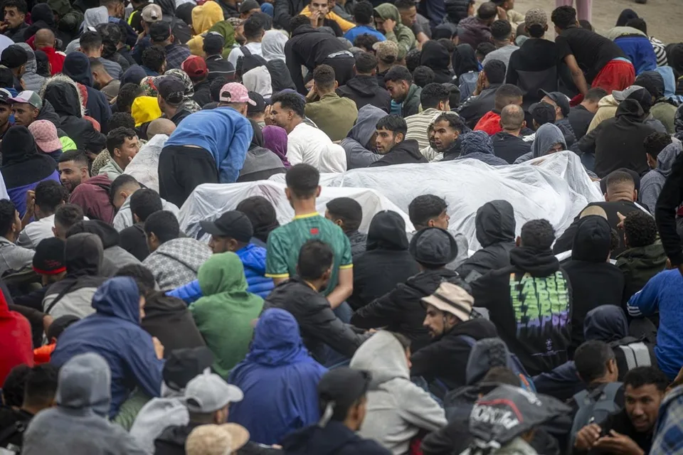 Agentes de Policía Nacional en las actuaciones de desalojo del embolsamiento de migrantes en la playa de El Trampolín, Ceuta, el 4 de octubre de 2026.