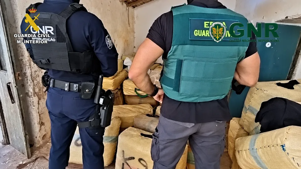 Agente junto a fardos de hachís incautados en una operación conjunta entre España y Portugal contra el narcotráfico en el Guadiana.